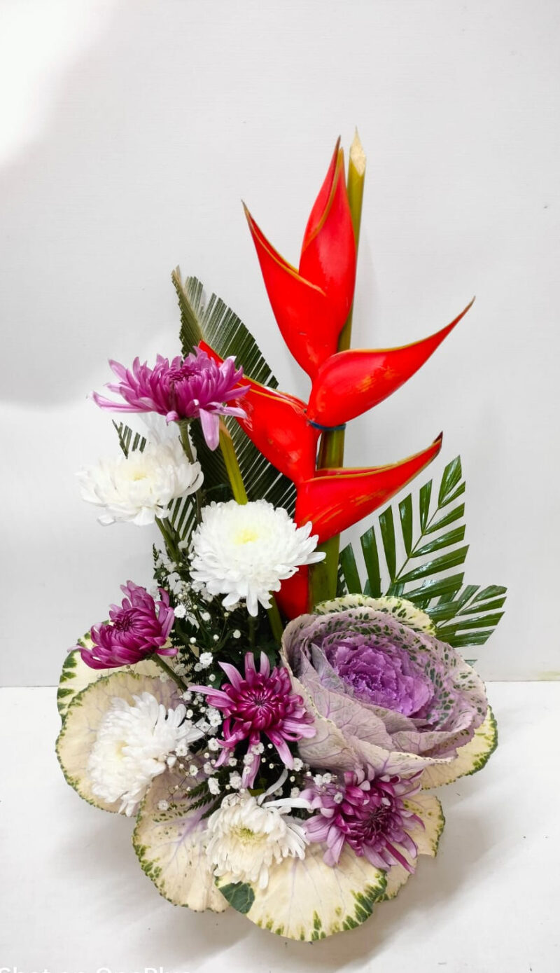 Flower arrangement of Heliconia, Chrysanthemums and Brassica in Glass Vase